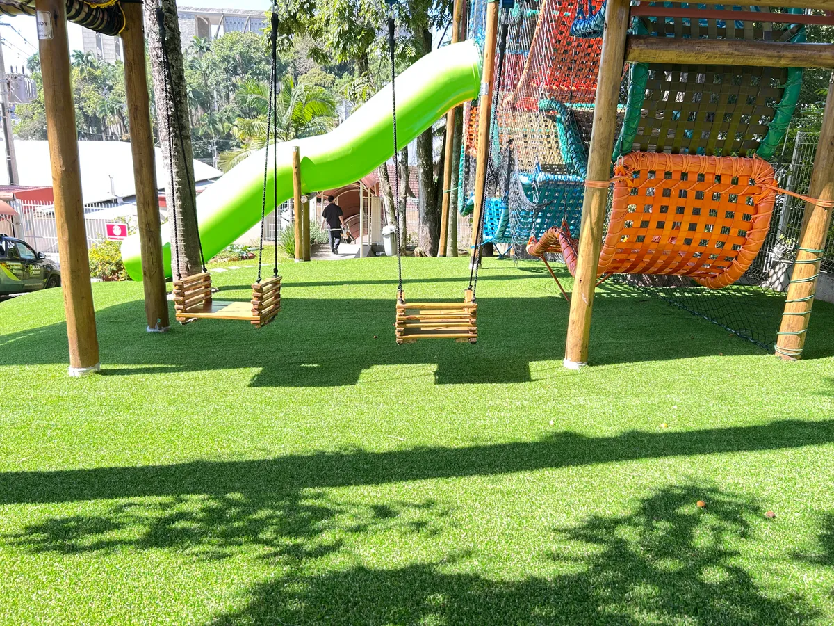 Área de balanços com grama sintética instalada em escola de Brusque — Decor Gramas