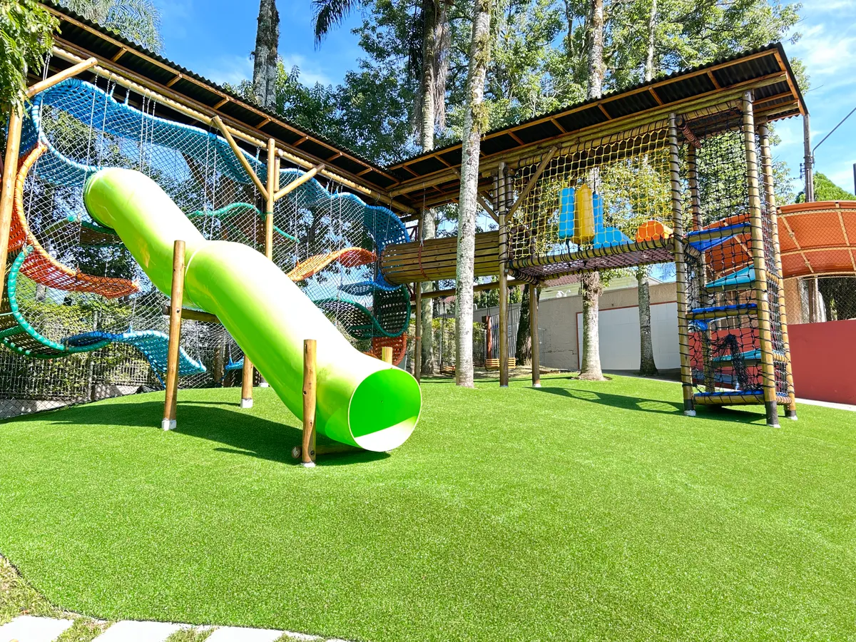 Vista panorâmica de playground com grama sintética instalado pela Decor Gramas em Brusque