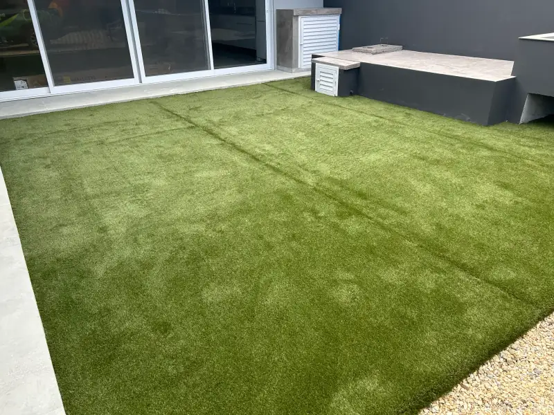 Área externa residencial com grama sintética em Balneário Camboriú